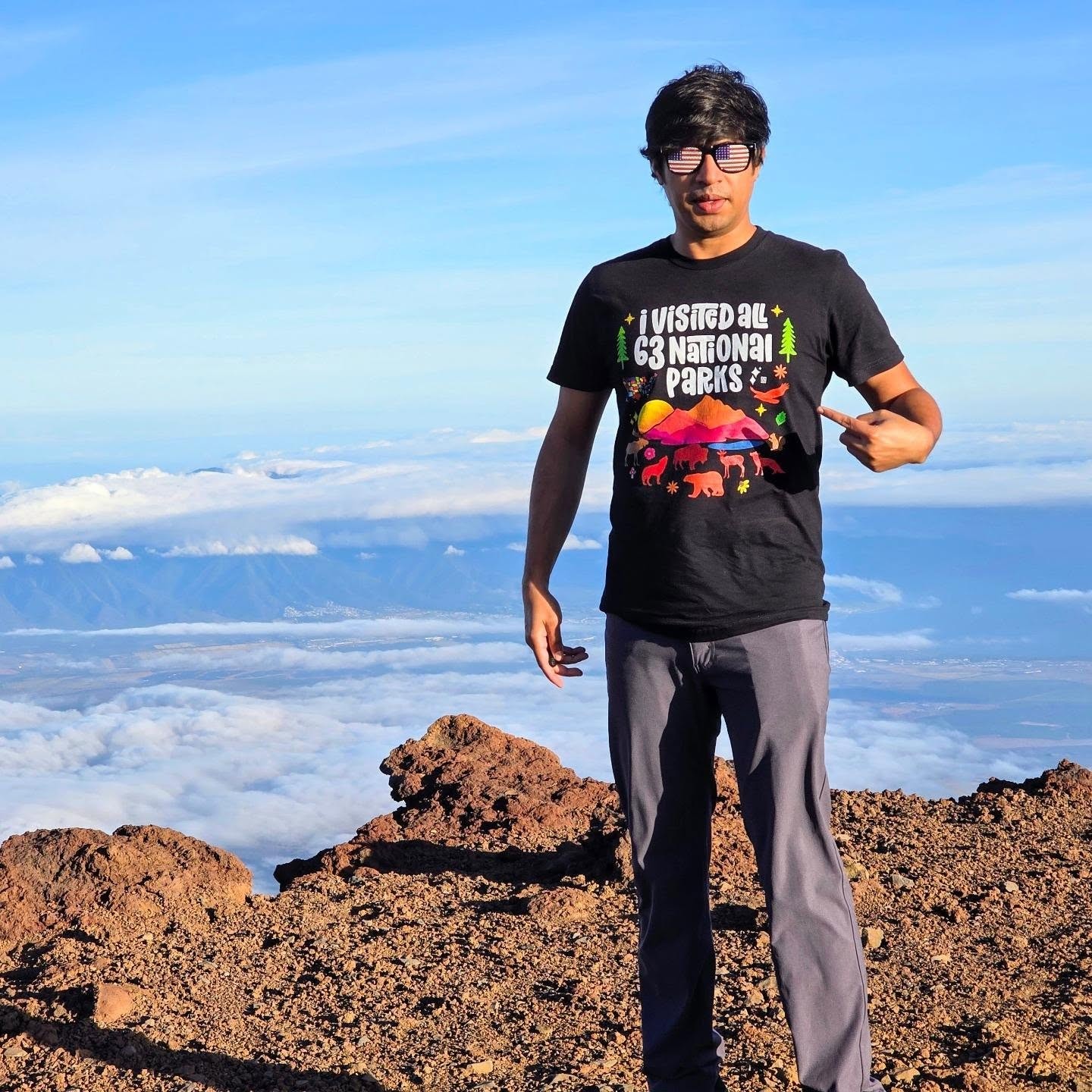 Anindya wearing his all-63-national-parks T-shirt above the clouds